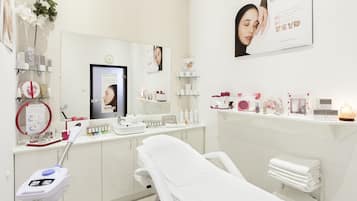 Una clínica moderna y limpia, con una paleta de colores blanca, que incluye un consultorio, una sala de recepción y una exhibición de productos médicos.