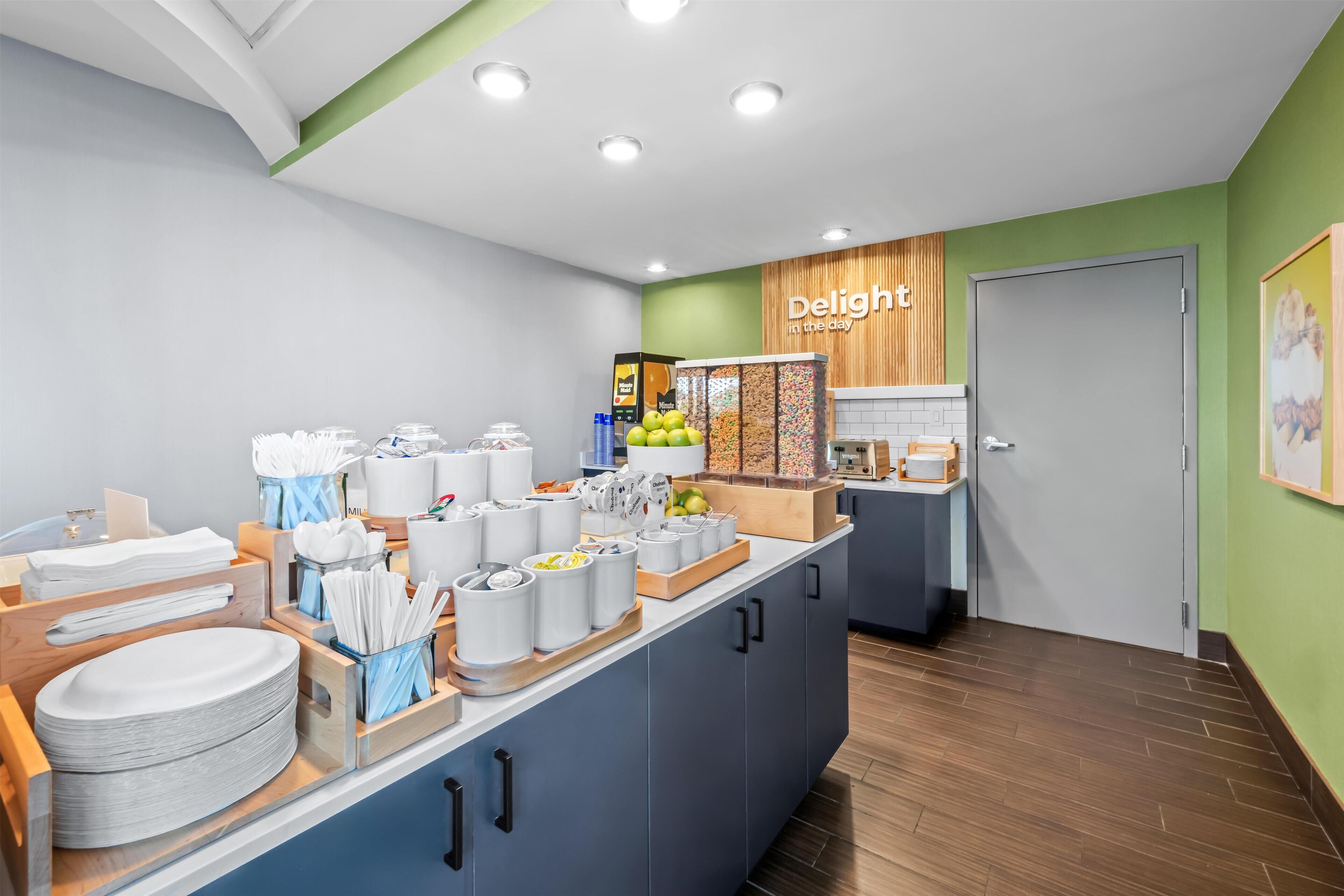 Un espace cuisine moderne avec un buffet, comprenant divers récipients à aliments, ustensiles et un panneau indiquant : « Savourez chaque instant ».