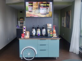 Una estación de bebidas con diversas opciones y una pantalla mostrando un anuncio de comida.