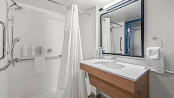 A modern bathroom with a shower, a sink, and a mirror.