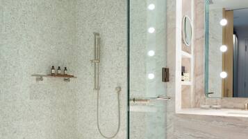 A modern bathroom with a glass-enclosed shower, a vanity with a mirror, and a towel rack.