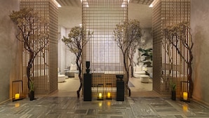 A modern interior with a central seating area, wooden partitions, and a patterned floor.