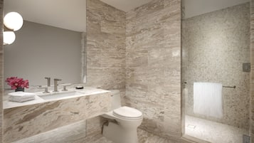 Ein modernes Badezimmer mit Marmorwaschbecken, Toilette und Dusche.