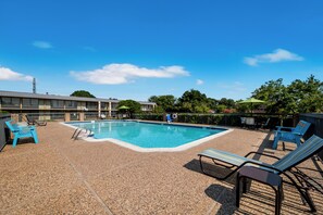 Una piscina al aire libre de temporada, sombrillas