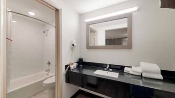 Un baño moderno con bañera, lavamanos y espejo.