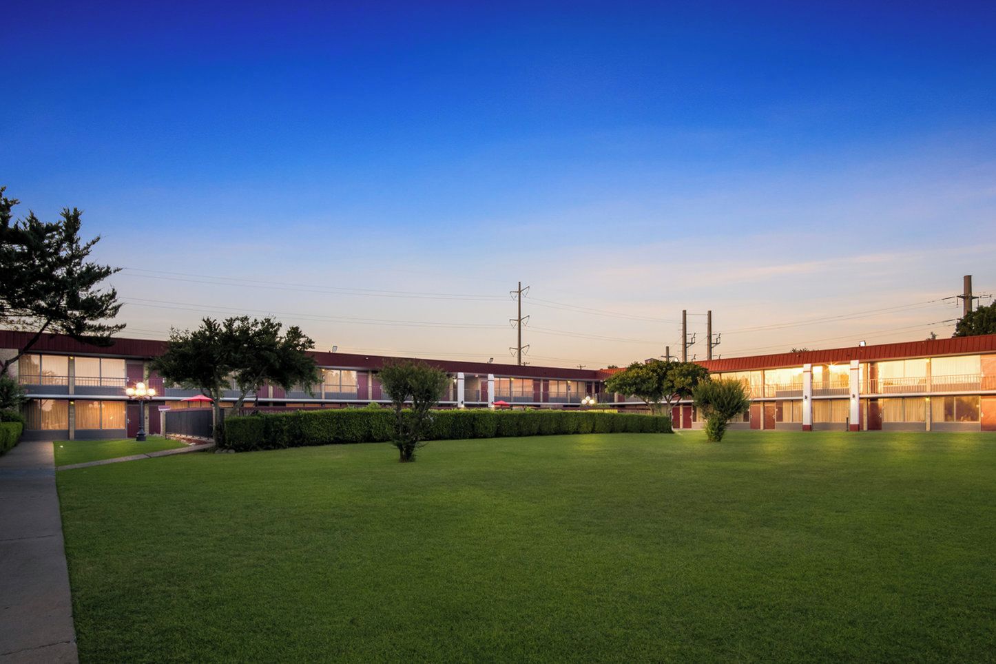 A hotel with a spacious lawn and multiple rooms with large windows.