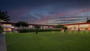 A building with a flat roof and a large lawn area.
