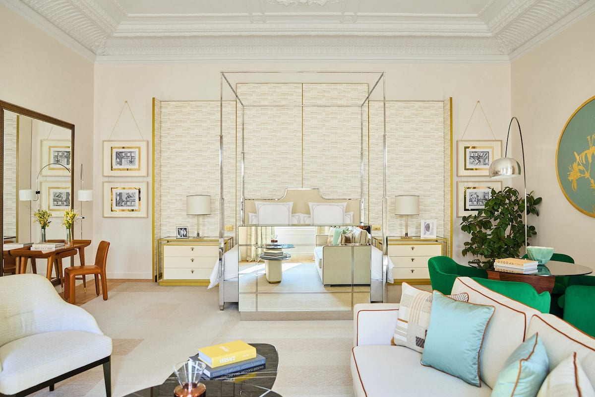 A spacious living room with a large sofa, a coffee table, and a dining area with a table and chairs.