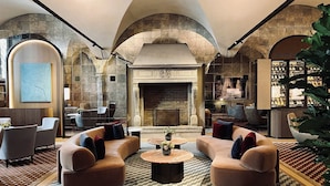 A spacious lobby with a fireplace, seating area, and a display of shoes. - Four Seasons Hotel Milano (Milan)