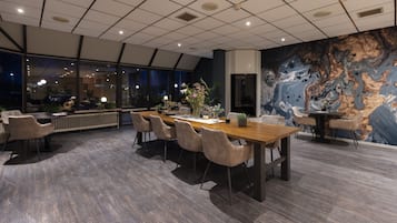 A modern conference room with a large table, comfortable chairs, and a decorative wall mural.