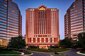 A high-rise hotel with a prominent entrance, multiple floors, and a well-maintained surrounding landscape.