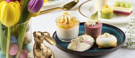A table with various desserts and a golden bunny figurine.