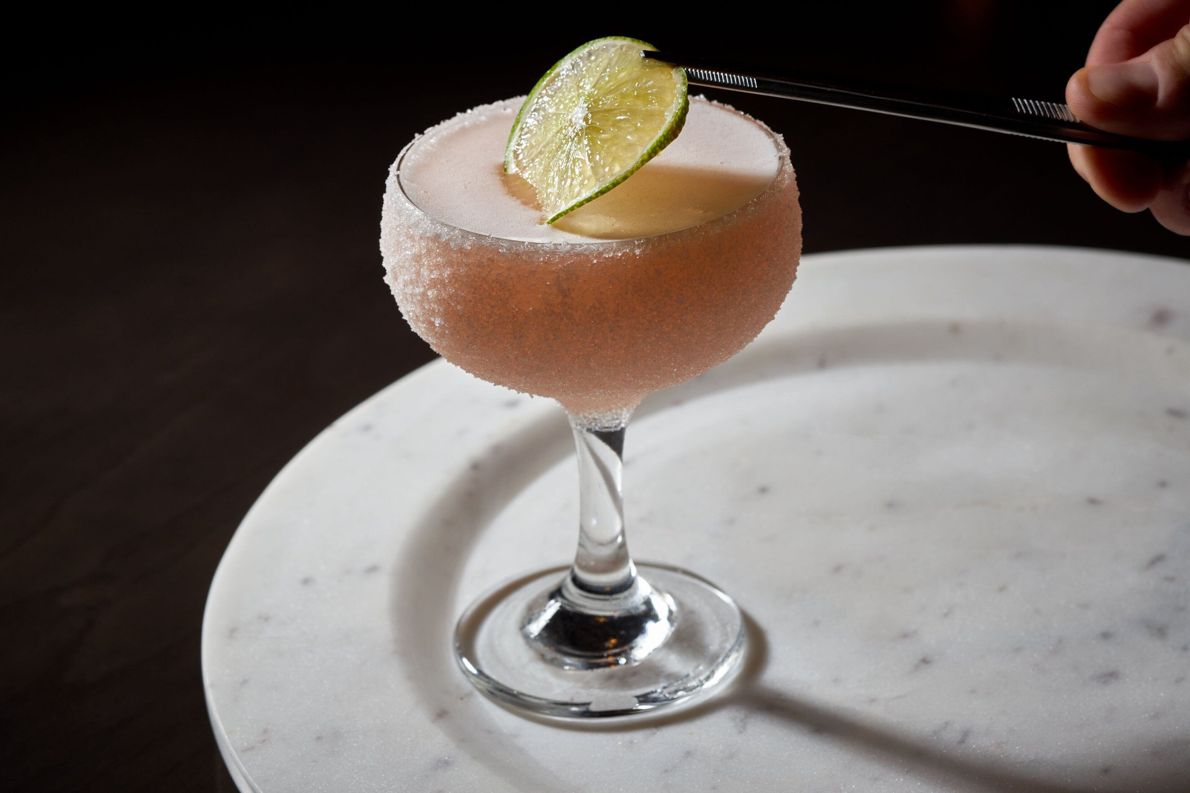 A margarita with a lime garnish on a salt-rimmed glass.