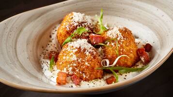 A dish with breaded chicken, garnished with herbs and cheese, served on a plate.