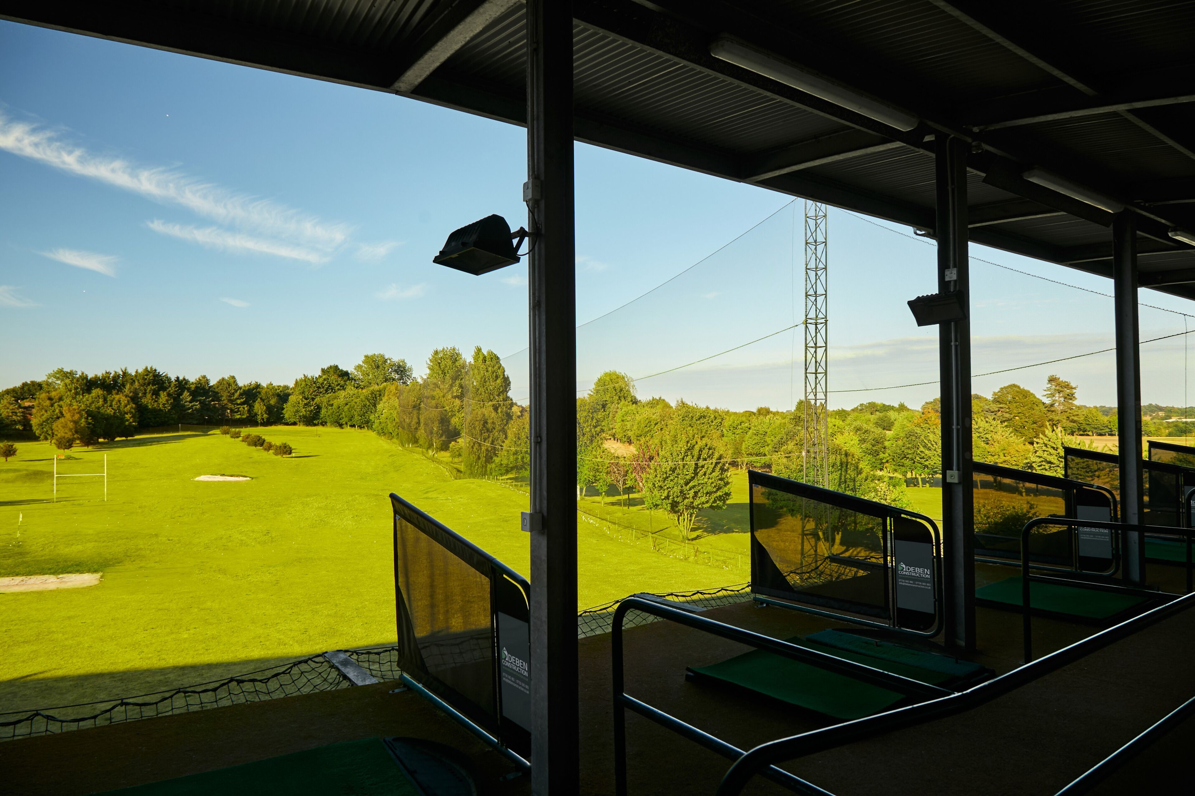 A covered seating area with a view of a golf course.