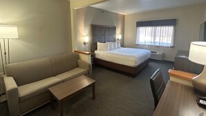 A hotel room with a bed, a sofa, a desk, and a lamp. - Best Western Plus Paper Valley Hotel (Appleton)