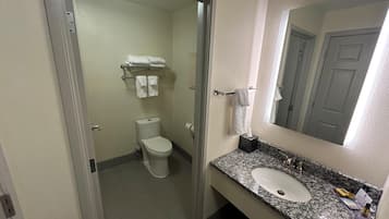 Un baño con inodoro, lavamanos y toallero.