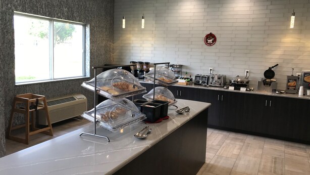 A modern kitchen with a marble countertop, a built-in stove, and a coffee station. - Best Western Plus Paper Valley Hotel (Appleton)