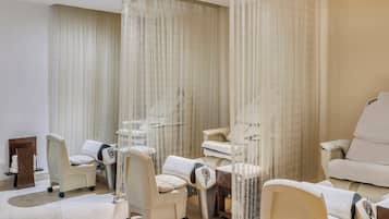 A spa room with multiple massage chairs, a small table, and a decorative wall piece.