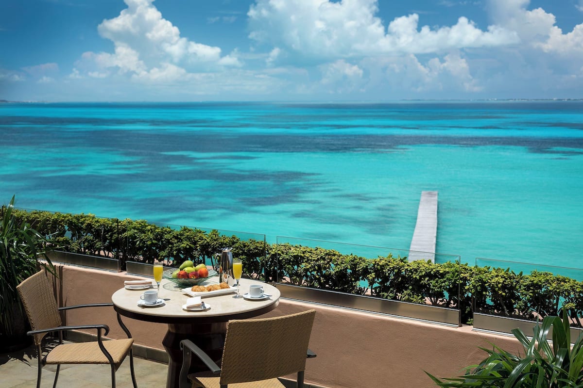 A table with breakfast items and a view of the ocean.