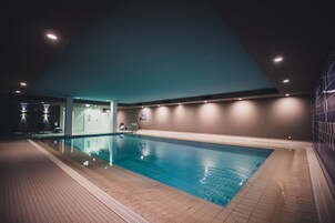 Una piscina cubierta, tumbonas