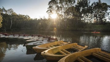 A calm river with several boats docked along the shore.