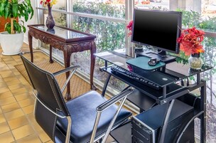 Un espacio de oficina en casa con un escritorio, computadora y dos sillas.