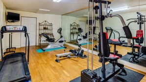 Ein Fitnessraum mit Laufbändern, Crosstrainern und Gewichtstrainern.