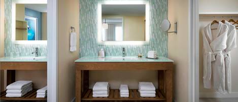 A bathroom with two sinks, a mirror, and a robe rack.