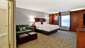 Una habitación de hotel con cama, sofá, escritorio y ventana.