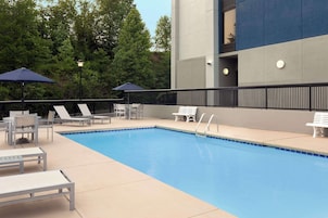 Una piscina al aire libre, sillones reclinables de piscina