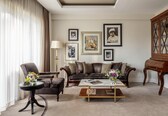 A living room with a sofa, armchair, coffee table, and a cabinet.