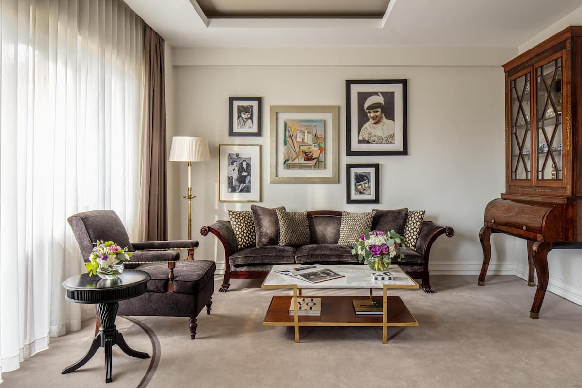 Ein Wohnzimmer mit Sofa, Sessel, Couchtisch und Schrank.