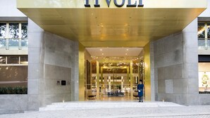 Una entrada moderna a un edificio con un letrero destacado que dice 'TIVOLI'.