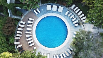 Una piscina al aire libre de temporada, sombrillas