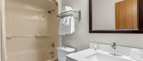 A bathroom with a bathtub, toilet, sink, and a towel rack.