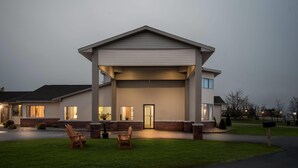 A modern two-story house with a covered front porch, a driveway, and a well-maintained lawn. - Days Inn by Wyndham Alpena (Alpena)