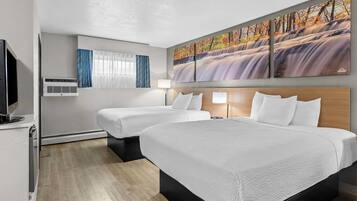 Habitación de hotel con dos camas, televisión, aire acondicionado, un cuadro de una cascada y una ventana con cortinas.