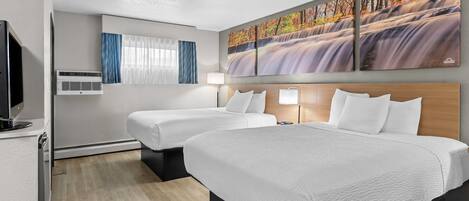 Ein Hotelzimmer mit zwei Betten, einem Fernseher, Klimaanlage, einem Bild eines Wasserfalls und einem Fenster mit Vorhängen.