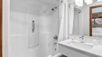 A modern bathroom with a bathtub, a sink, and a mirror.