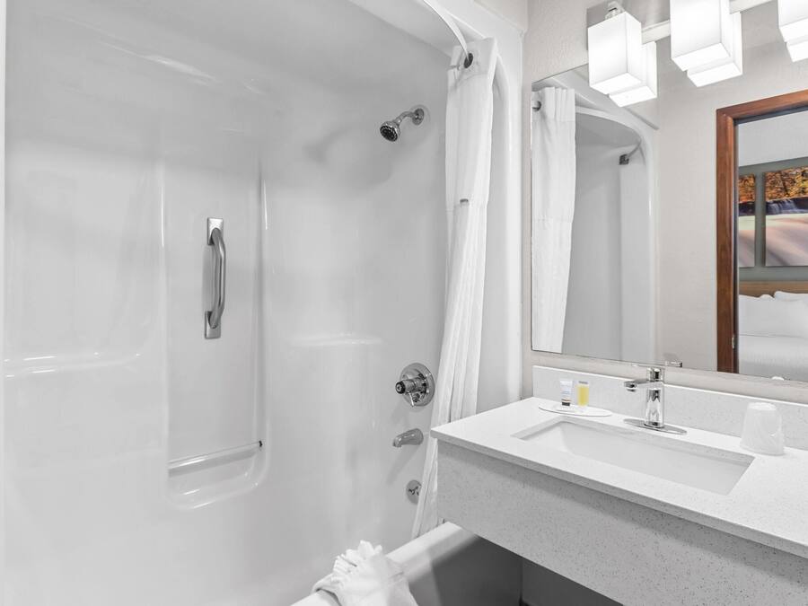 A modern bathroom with a bathtub, a sink, and a mirror.