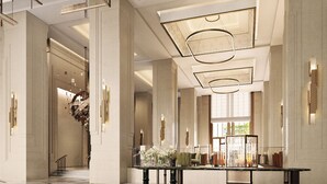 Eine geräumige Lobby mit hohen Decken, großen Säulen und einem zentralen Tisch mit floralen Dekorationen.