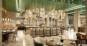 Een modern interieur met een centraal gelegen bar, zitgedeeltes en een hoge plafond met decoratieve verlichting.