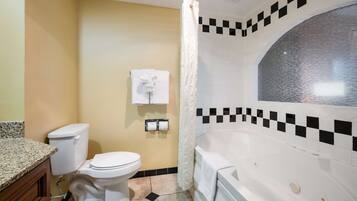 Une salle de bain équipée de toilettes, d’une baignoire et d’un rideau de douche.