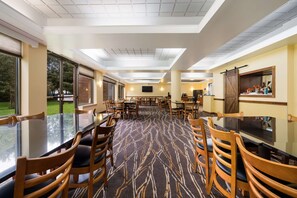 Relax in a spacious room with a central carpeted area, large windows, and a flat-screen TV.