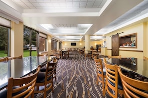 Relax in a spacious room with a central carpeted area, large windows, and a flat-screen TV.