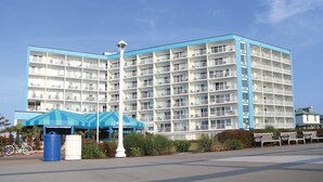 A multi-story hotel with balconies, a blue awning, and a bicycle parked outside.