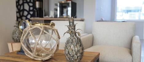 A wooden table with two decorative glass vases and a mirror.