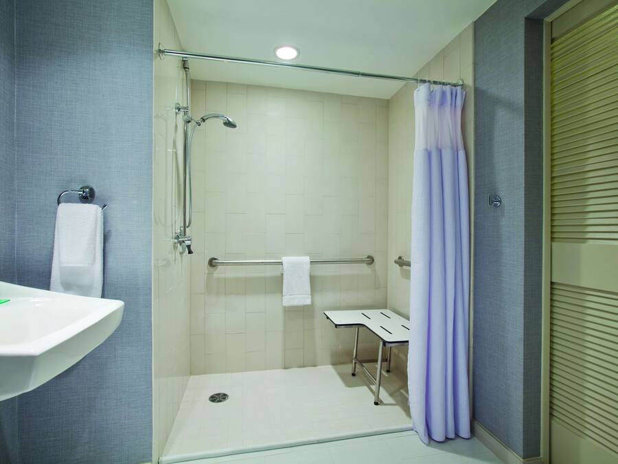 A modern bathroom with a shower, a sink, and a toilet.