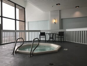 Relax by the serene indoor pool, featuring a hot tub and seating area.